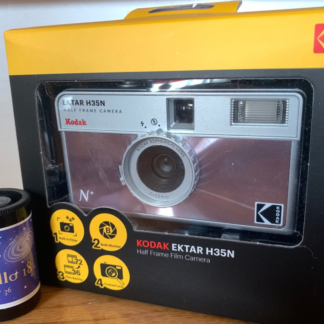 Kodak Ektar H35N 35mm half-frame film camera in glazed pink, with film and filters