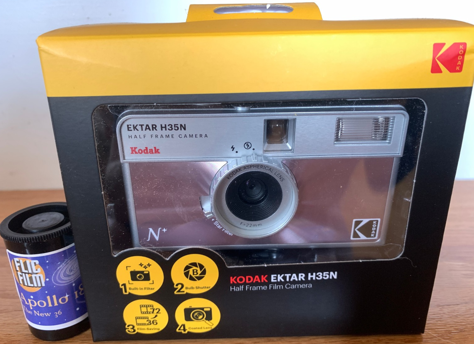 Kodak Ektar H35N 35mm half-frame film camera in glazed pink, with film and filters