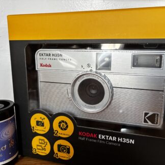 Kodak Ektar H35N 35mm half-frame film camera in striped silver, with film and filters