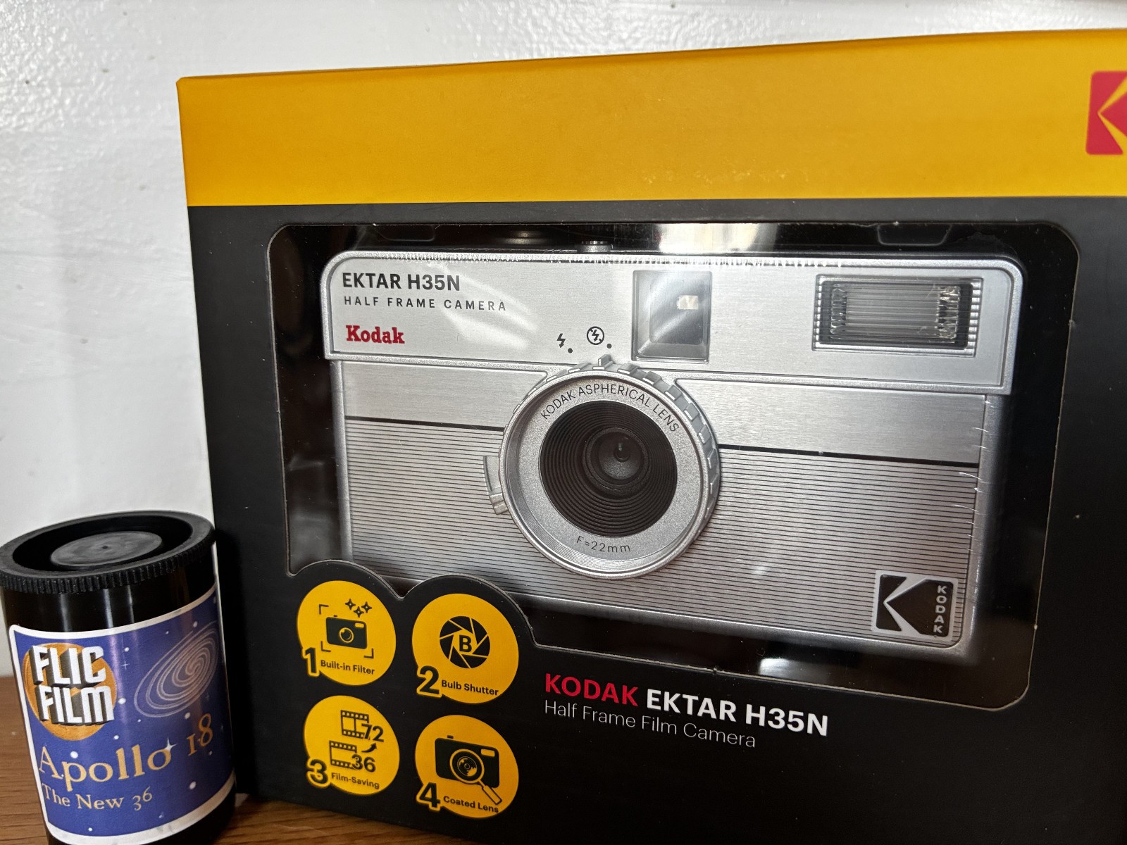 Kodak Ektar H35N 35mm half-frame film camera in striped silver, with film and filters