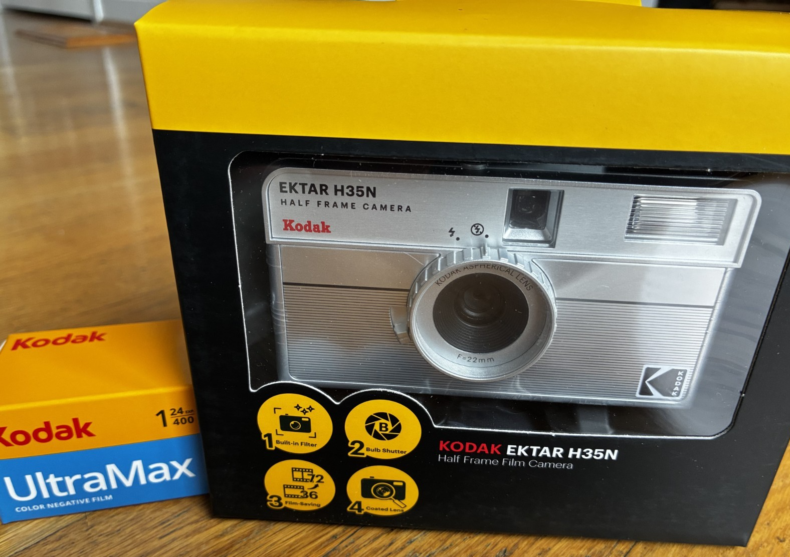 Kodak Ektar H35N 35mm half-frame film camera in striped silver, with film and filters