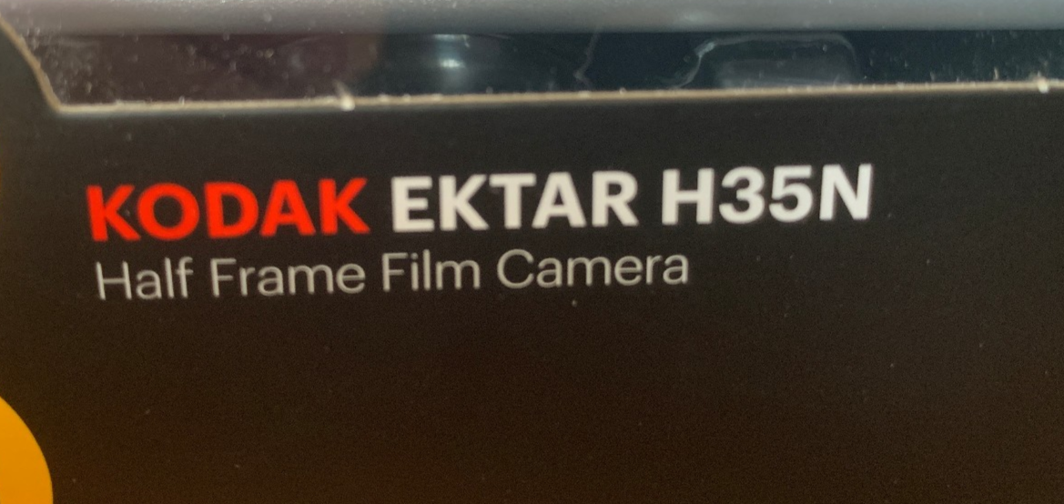 Kodak Ektar H35N 35mm half-frame film camera in striped silver, with film and filters