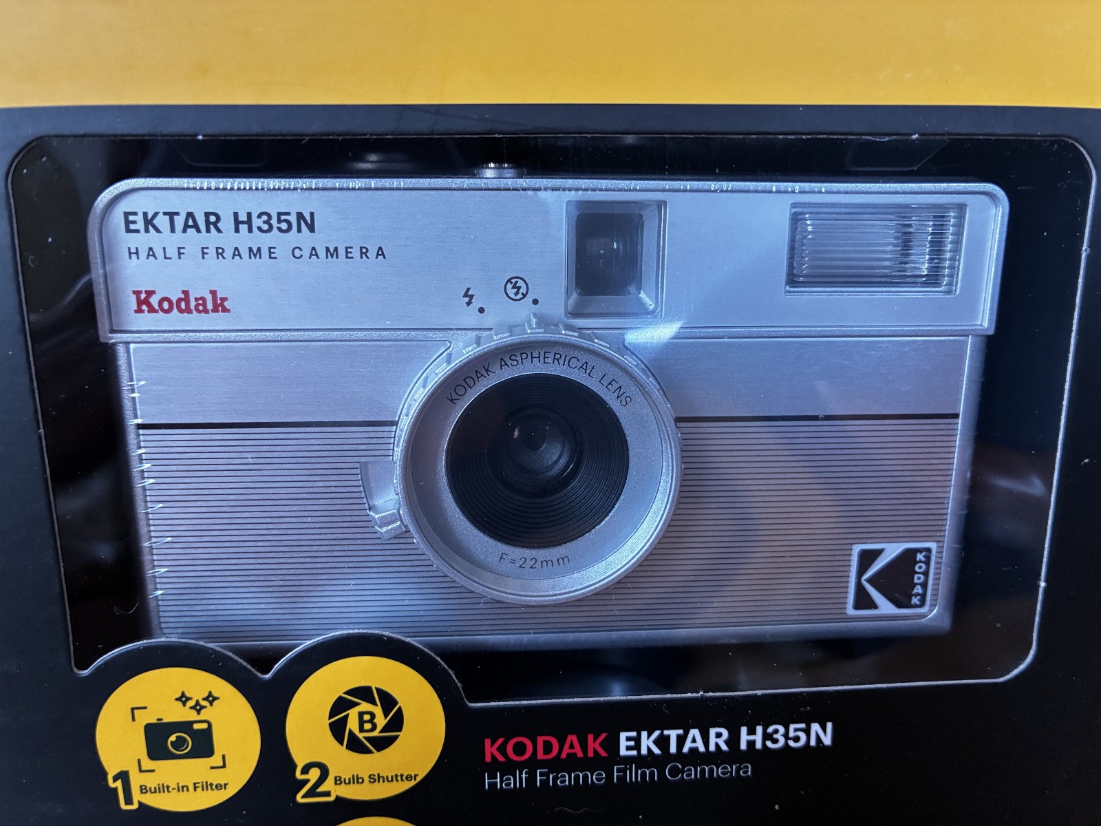 Kodak Ektar H35N 35mm half-frame film camera in striped silver, with film and filters